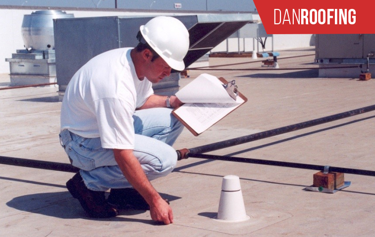 Inspector checking roof condition and reviewing warranty coverage documents.