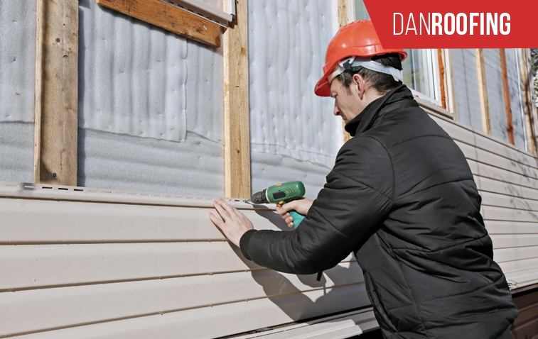 Worker installing roof flashing on a roof to prevent water damage.